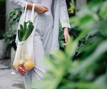 Woman with bag filled fruits and vegetables